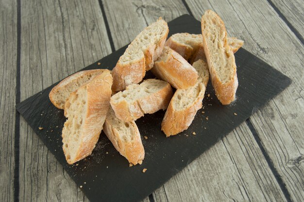 Sliced ​​bread, on a black slate plate.