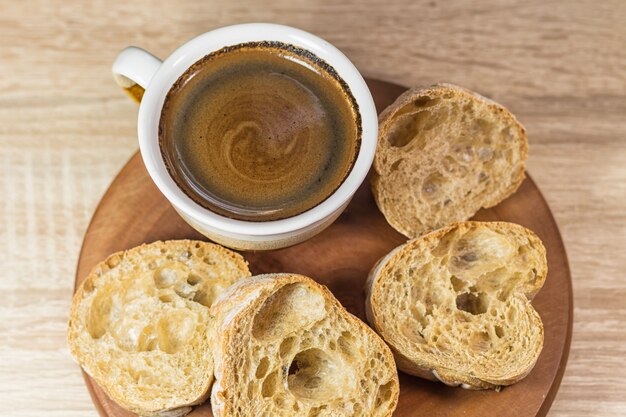 Sliced bread and a cup of coffee on a wooden board 