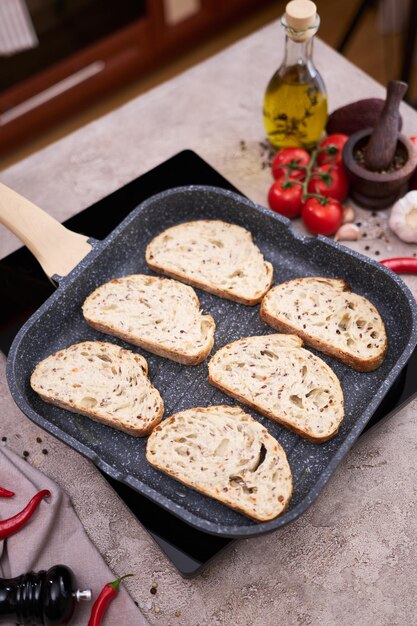 Sliced bread fried on grill frying pan at domestic kitchen