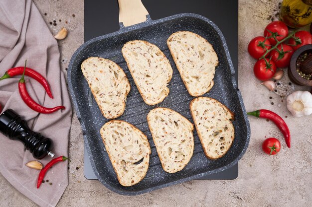 Sliced bread fried on grill frying pan at domestic kitchen