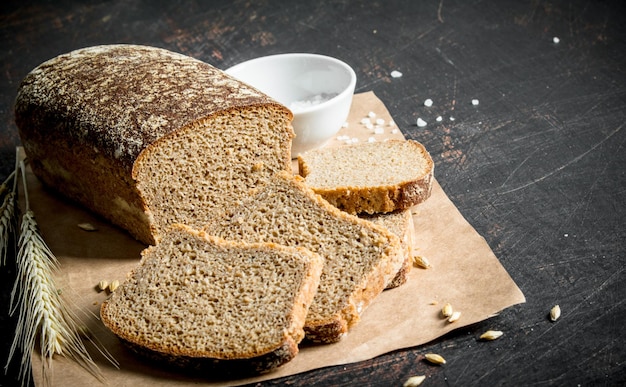 Sliced bread on paper with salt and spikelets