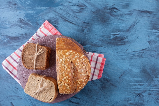 Fette di pane su un piatto su un asciugamano, sul blu.