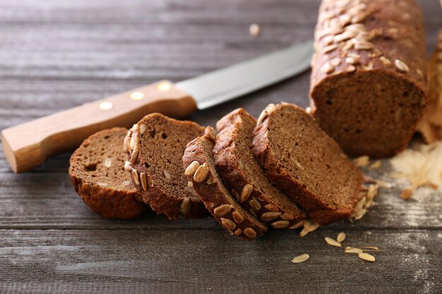 Sliced bread with seeds on wooden table closeup