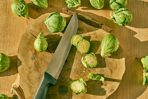 Sliced Brussels sprouts and a chefs knife on a wooden kitchen counter.