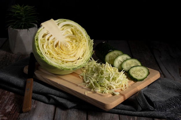 Sliced cabbage and cucumber lie on the table in the kitchen