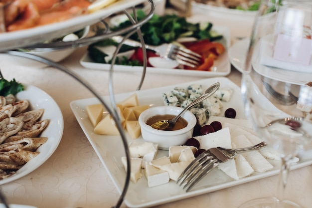 Sliced cheese platter with honey and grape