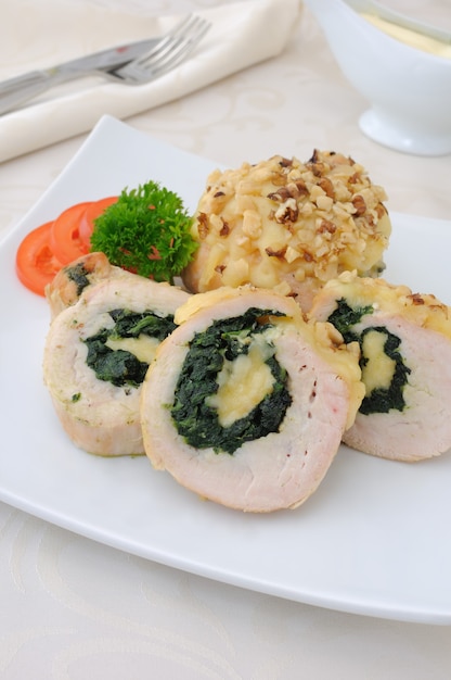 Sliced a chicken roll stuffed with spinach and mozzarella and cheese with walnut