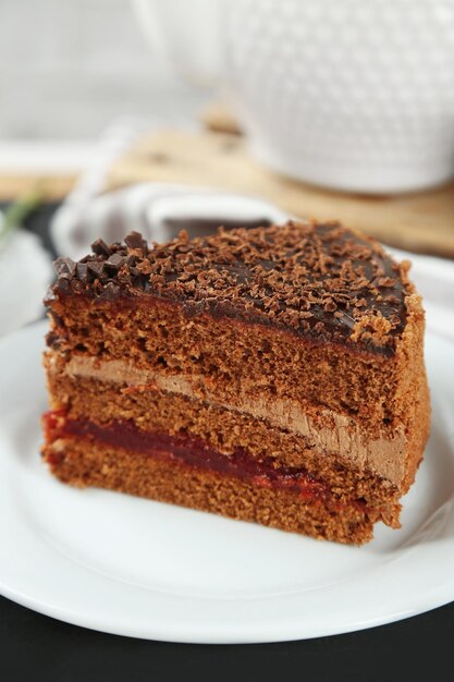 Sliced chocolate cake on plate on wooden table background