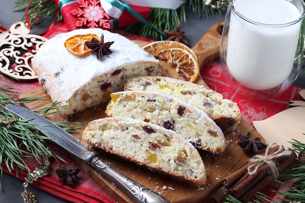 Sliced Christmas tasty stollen with dry fruits and glass of milk. Traditional German treats.