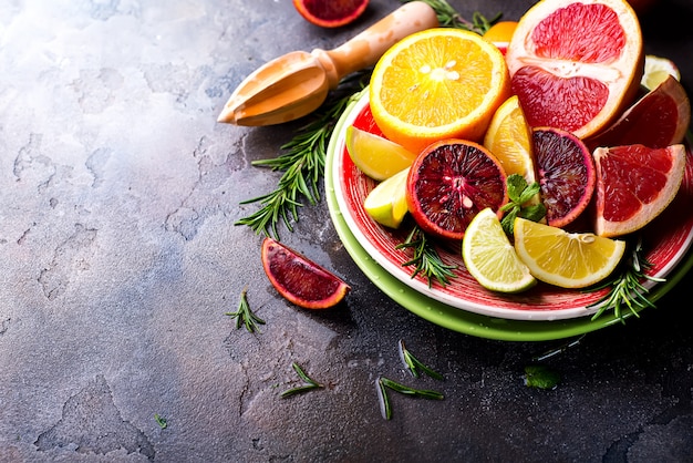 Sliced citrus fruit on the plate on stone dark background