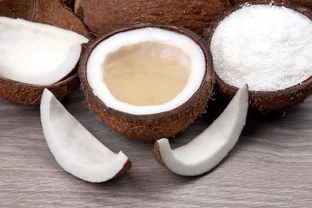 Sliced coconut with natural milk and coconut on a wooden board.