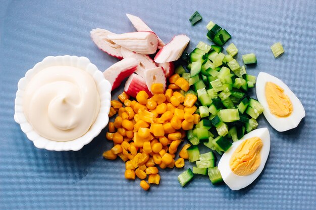 Sliced crab sticks diced cucumber and egg with mayonnaise for salad