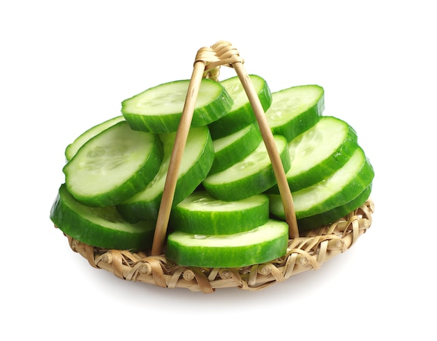 Sliced cucumber in a wicker basket on white