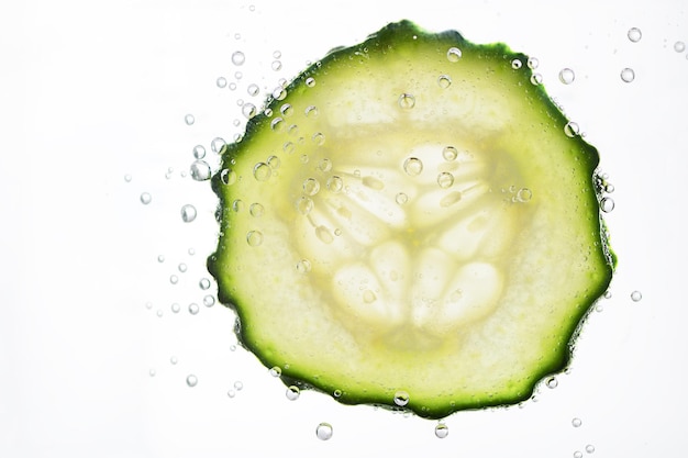 Sliced cucumber with water bubbles on white background Skin moisturizing cosmetics concept