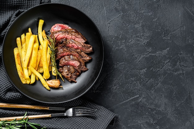 Sliced Denver steak with French fries