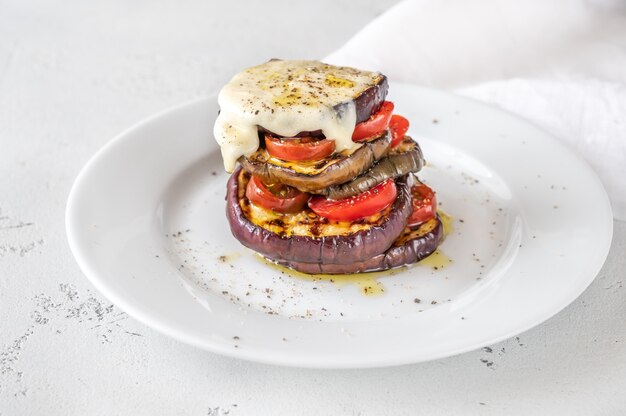 Sliced eggplant with cherry tomatoes and melted mozzarella