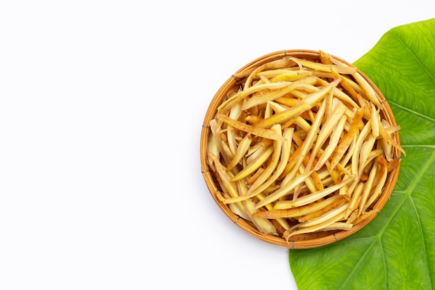 Sliced finger root in bamboo basket on white background.