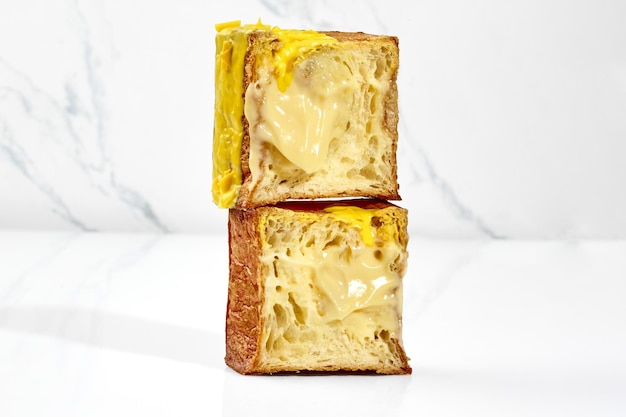 Sliced flaky cubic croissant with vanilla custard filling yellow glaze and chocolate chips