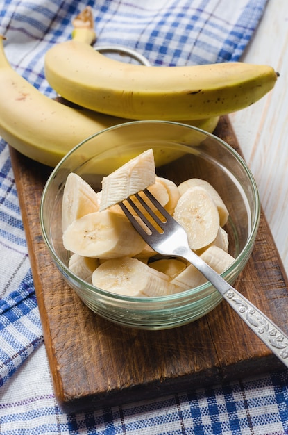 Foto banana fresca affettata in una ciotola di vetro.