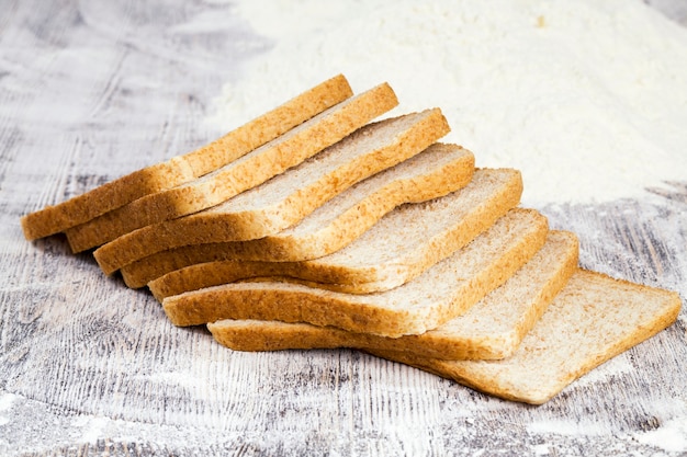 Sliced fresh bread in white wheat flour, closeup of food on the table