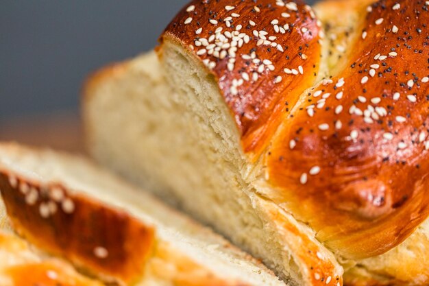 Sliced fresh challah bread on the wood table.