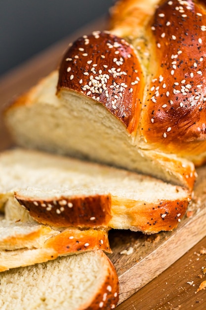 Нарезанный свежий хлеб халы на деревянном столе.