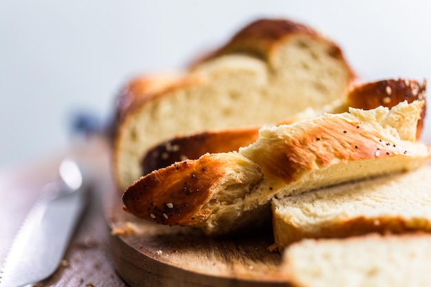 Sliced fresh challah bread on the wood table.