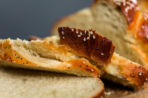 Sliced fresh challah bread on the wood table.