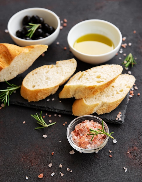 Sliced fresh crusty baguette with olive and spices 