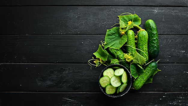 Sliced fresh green cucumbers. On a black background. Top view. Free space for your text.