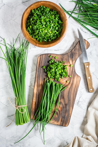 Sliced fresh green onions on a cutting board on the table top
and vertical view