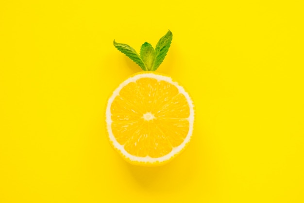 Sliced fresh lemon and mint on yellow background