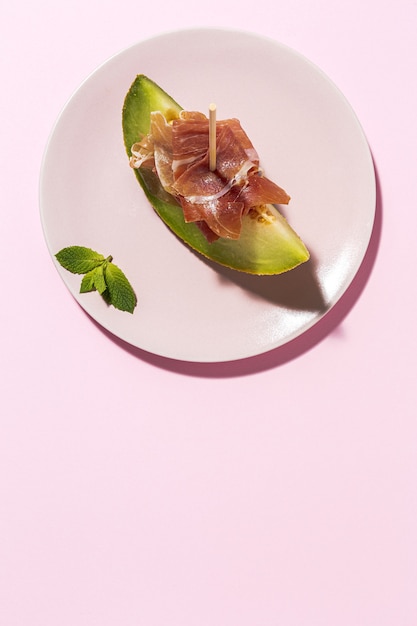 Sliced fresh melon with ham with sunlight on colorful backgrounds. Spanish food concept