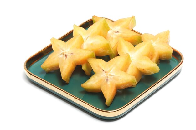 Sliced fresh organic star fruit delicious in a green plate isolated on white background