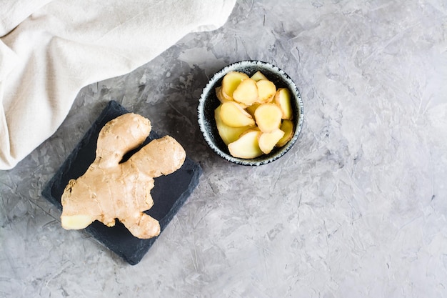 Sliced fresh raw ginger root in a bowl on the table Alternative medicine Top view