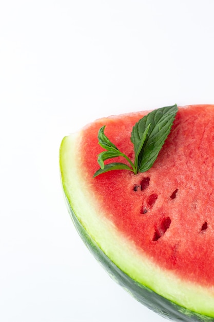 Sliced of fresh red ripe watermelon with green leaves of mint