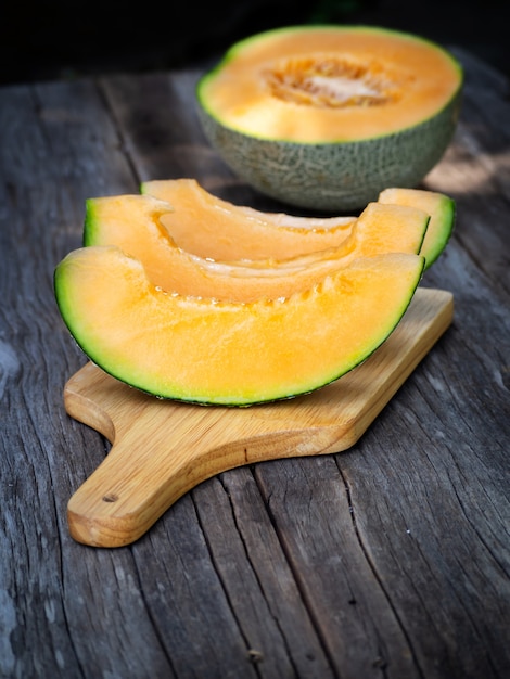 Foto affettato melone dolce fresco sul bordo di legno. frutta dolce