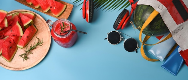 Sliced fresh watermelon and smoothie on blue background.