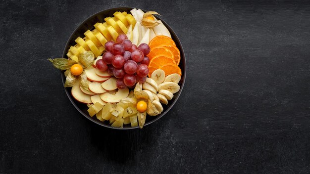 Sliced fruits on a plate dessert On a dark background