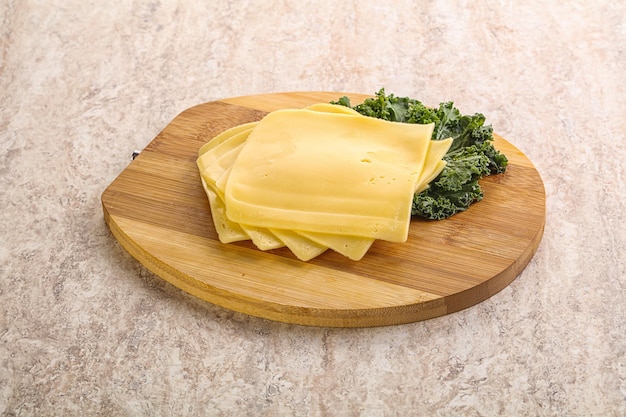 Sliced Gouda cheese over board
