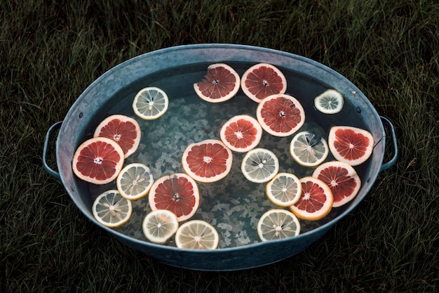 Sliced grapefruits and lemons in water in a basin