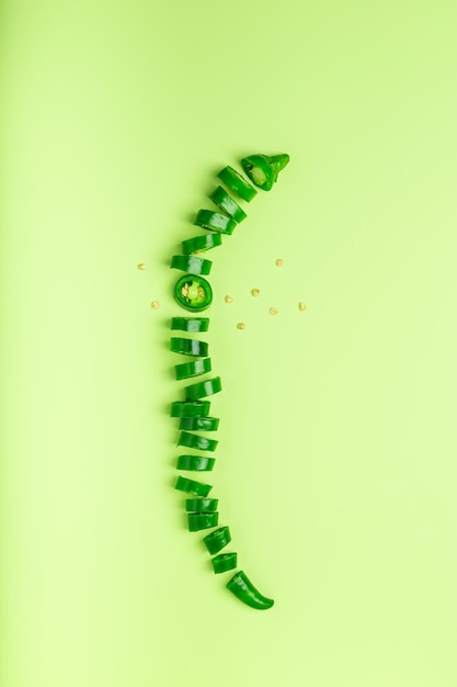 Нарезанный зеленый перец чили лежит на цветном фоне Концепция органических продуктов питания Вид сверху плоской планировки
