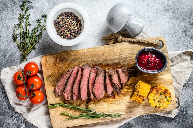 Sliced grilled black Angus marbled beef steak on a wooden chopping Board. Top view.