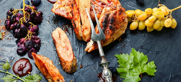 Sliced grilled chicken breast with grape sauce.Chicken fillets on slate concrete background