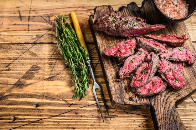 Sliced grilled machete skirt meat beef steak on a wooden cutting board