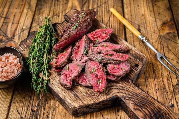 Sliced grilled machete skirt meat beef steak on a wooden cutting board