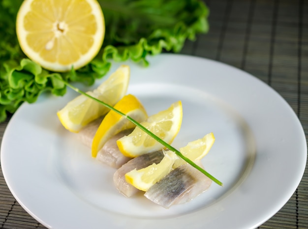 Photo sliced herring filet with lemon