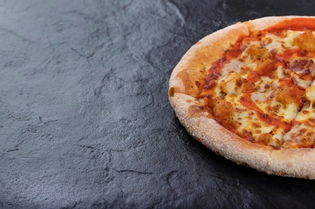 Sliced hot delicious pizza placed on a stone table. 