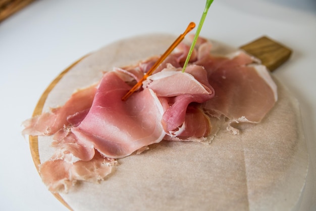 Foto prosciutto affettato su una tavola di legno