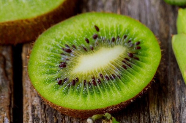 Sliced kiwi fruits on wooden table top view macro